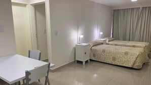 A hotel room with a bed, a desk, and a chair. - Lofts & Suites Rosario (Rosario)
