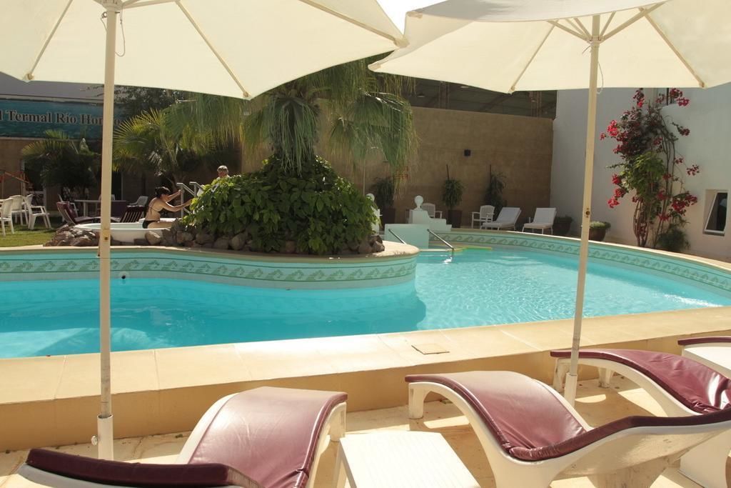 A pool area with lounge chairs and umbrellas.