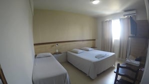 Habitació d'hotel amb dos llits, una taula i una cadira.