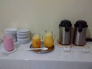 A breakfast buffet with various food and drink options, including a pink yogurt, orange juice, and hot beverages in thermos containers. - Hotel Skala (Foz do Iguaçu)