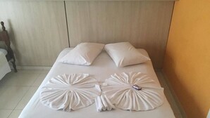 A neatly made bed with two pillows and decorative pillows on the bed. - Hotel Skala (Foz do Iguaçu)