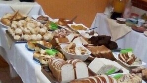A buffet table with various food items and a large loaf of bread. - Hotel Skala (Foz do Iguaçu)