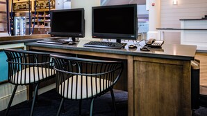 Un espace bar équipé de deux écrans, d’un clavier, d’un téléphone et de deux chaises.