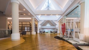 A spacious atrium with high ceilings, large windows, and modern furniture. - Holiday Inn Newport News - Hampton by IHG (Newport News)