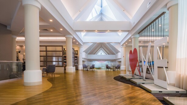Un vaste atrium doté de hauts plafonds, de grandes fenêtres et de mobilier moderne.