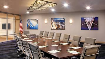 A conference room with a long table, chairs, and artwork on the walls.