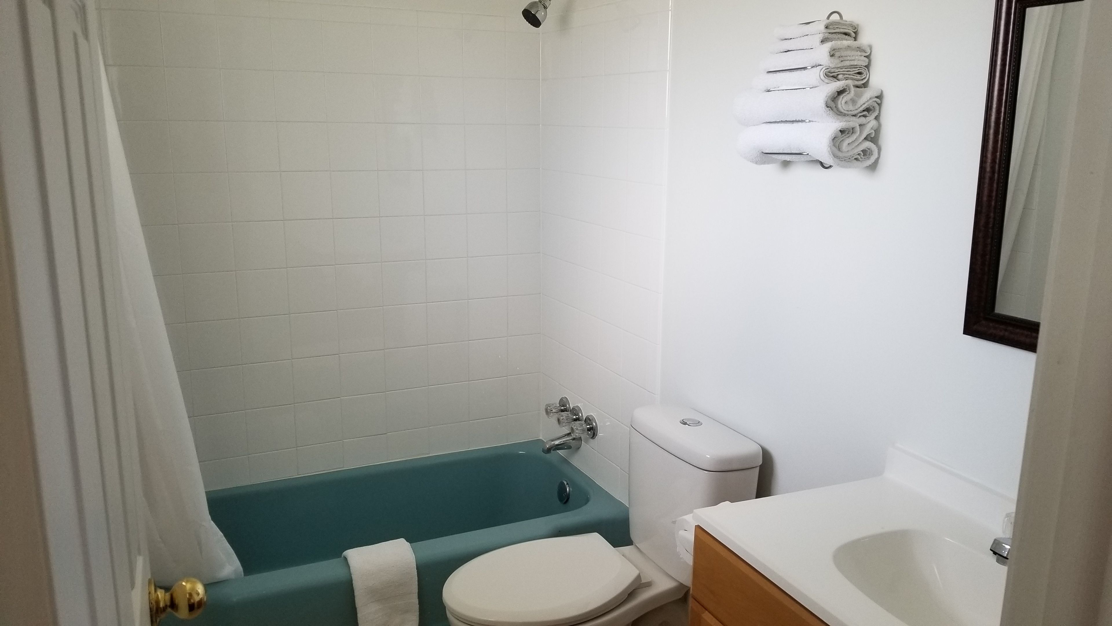A bathroom with a bathtub, toilet, and sink.