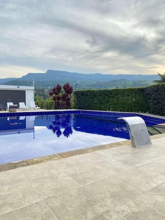 Una piscina al aire libre, sombrillas, sillones reclinables de piscina. Hotel Palmeras de Luz
