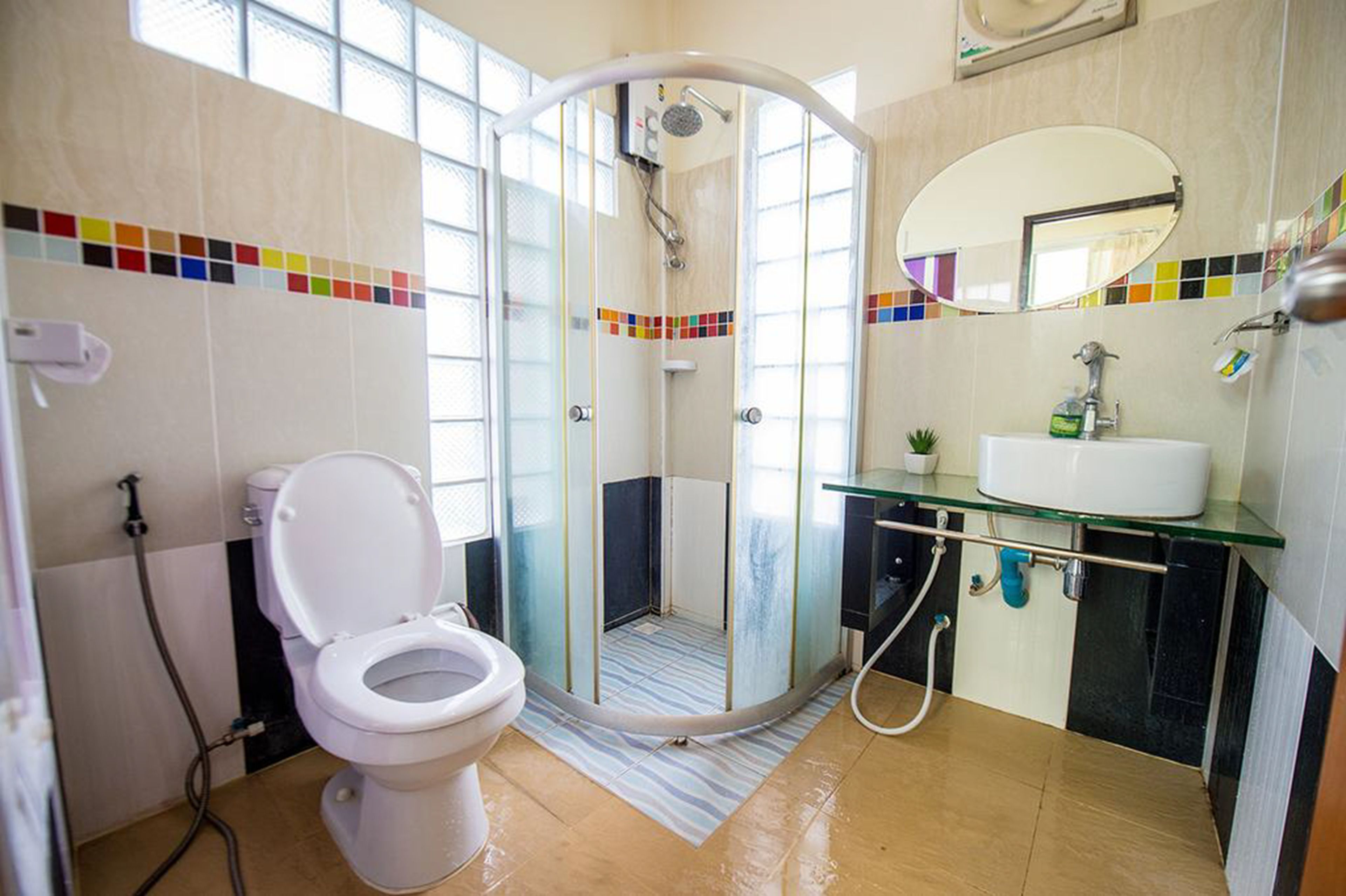 Une salle de bain moderne avec une douche à parois de verre, des toilettes et un lavabo avec un miroir au-dessus.
