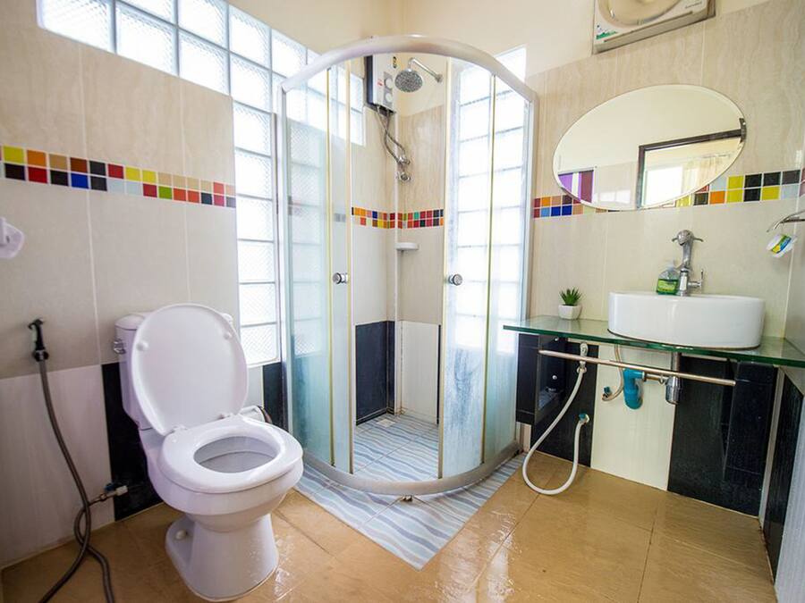 Une salle de bain moderne avec une douche à parois de verre, des toilettes et un lavabo avec un miroir au-dessus.