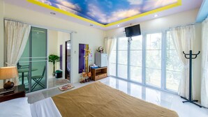 A modern hotel room with a large bed, a ceiling mural, a TV, and a balcony with curtains. - Poomvarin Resort (Nakhon Nayok)