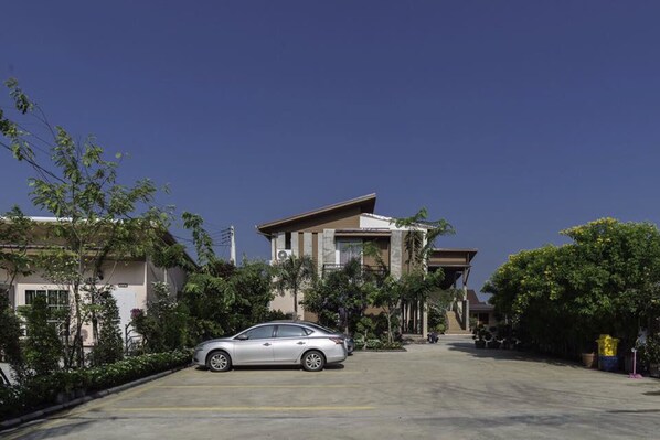 A residential street with a parked car, houses, and trees.