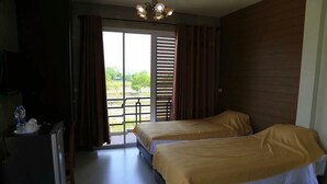 A room with two beds, a desk, and a sliding glass door to a balcony. - Nava Resort (Pak Phli)