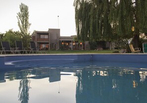 Een buitenzwembad en ligstoelen