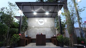Un espacio de estar al aire libre cubierto con un muro de concreto y un letrero que dice "Yamwon 3soshn".