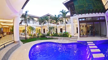 Una piscina al aire libre, sillones reclinables de piscina