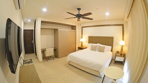 A hotel room with a bed, two bedside tables with lamps, a ceiling fan, a TV, a desk, and a chair. - Hotel Gran Balcón (Granada)