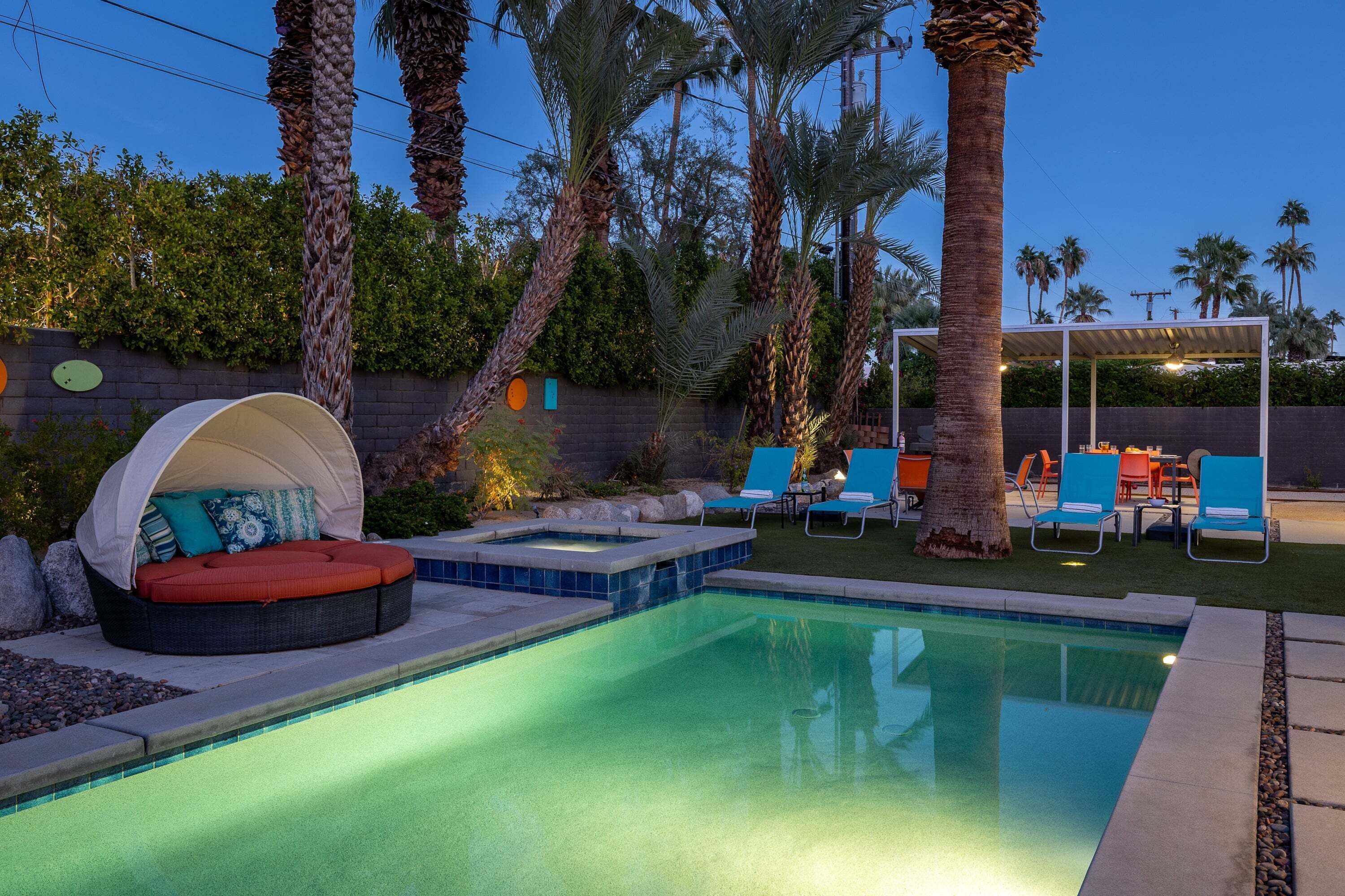 A swimming pool with lounge chairs and a covered seating area.