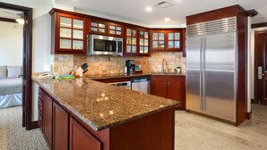 A modern kitchen with granite countertops, stainless steel appliances, and wooden cabinetry.
