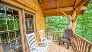A wooden deck with two rocking chairs and a single chair, overlooking a forested area. - Rock n Rhapsody - Blue Ridge Log Cabin - Minutes to West Jefferson - Fireplace - Foosball (West Jefferson)