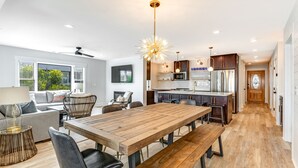 Una cocina moderna con una mesa de comedor de madera, sillas negras y una isla central.