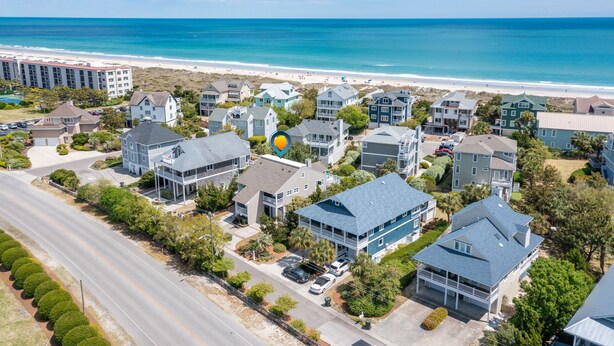 Una zona residencial costera con propiedades frente al mar, una carretera y una playa.