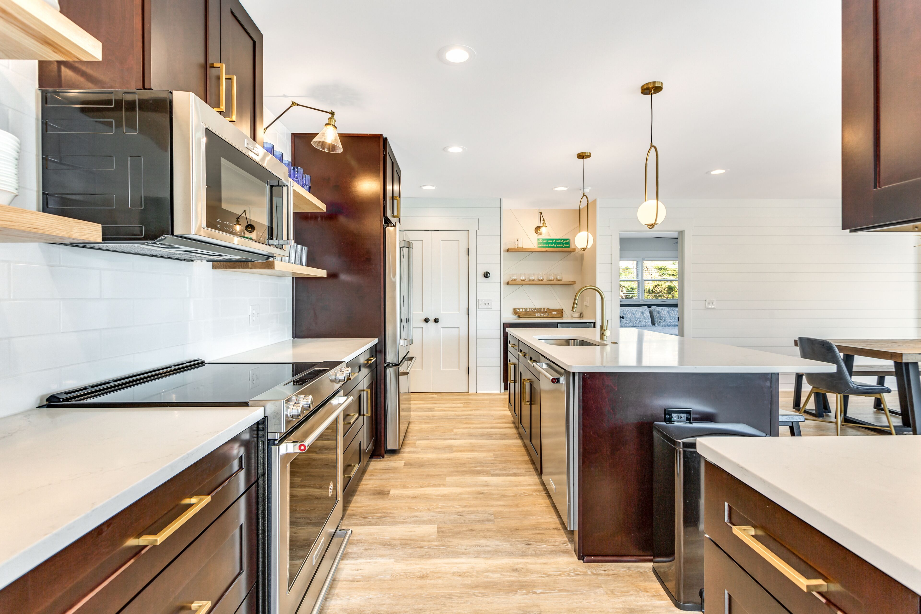 A modern kitchen with stainless steel appliances, wooden cabinets, and a central island.