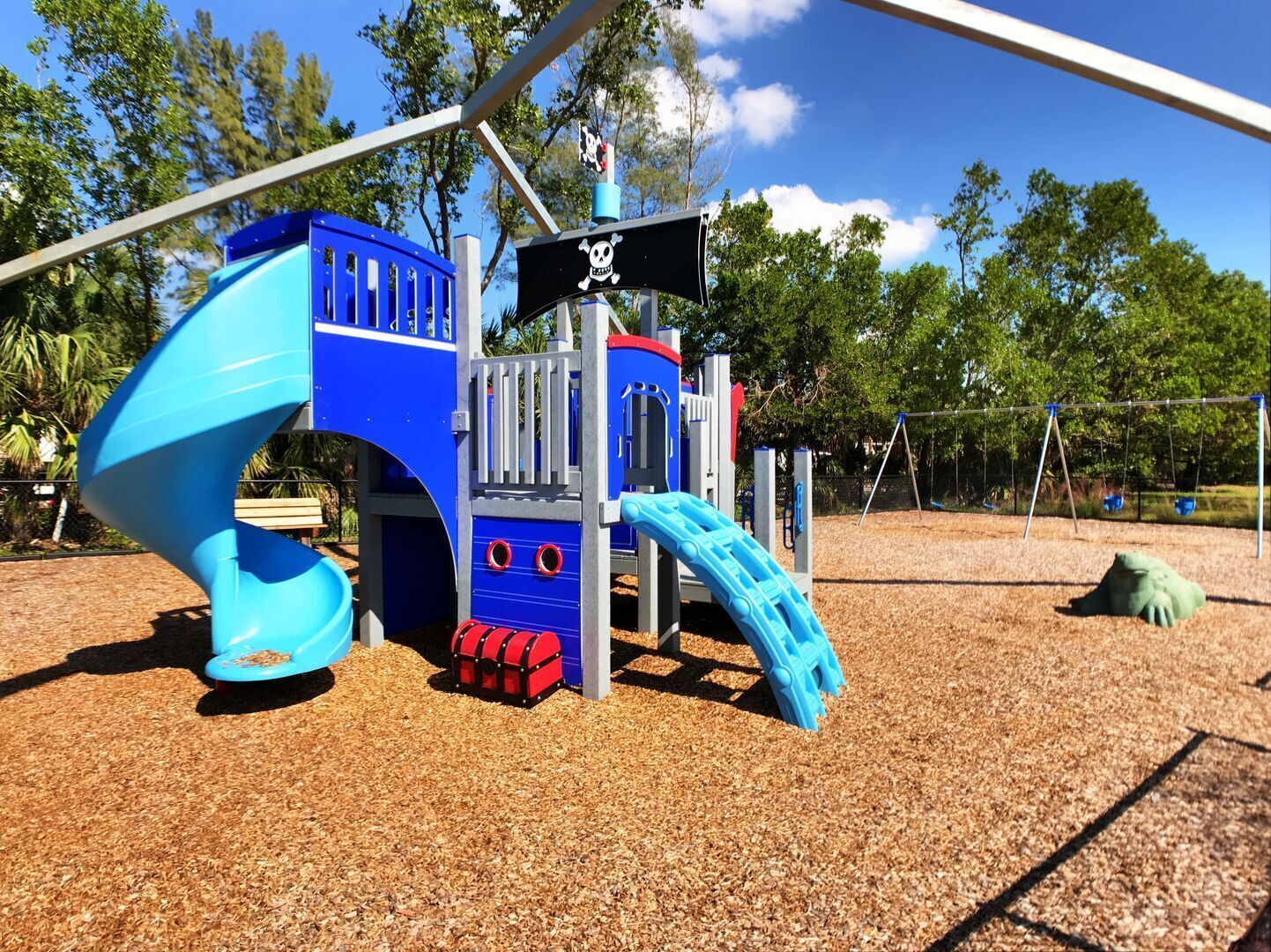 A playground with a pirate-themed play structure, including slides and climbing areas.