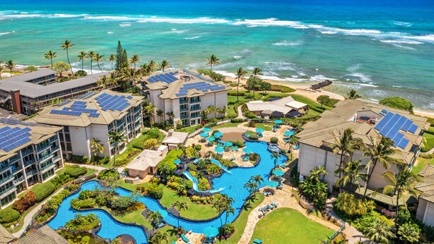 Un resort con varias edificaciones, una piscina y vista al océano.