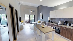 A modern kitchen with a dining area, a ceiling fan, and a view to the outside. - 1 Bedroom * HighSpeedConnection* Downtown quite & safe-5th ave steps away (Playa del Carmen)