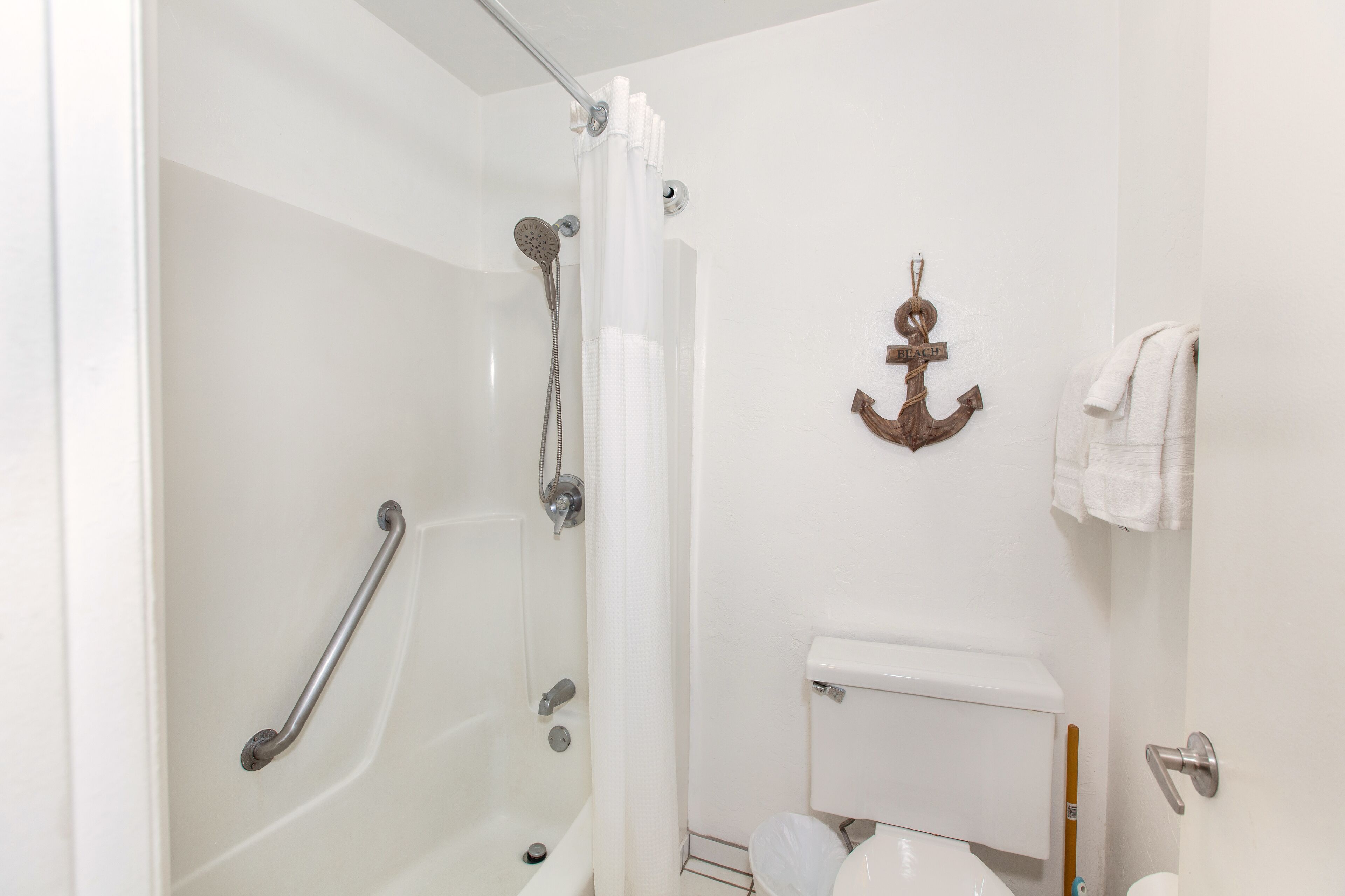 Een badkamer met een bad, toilet en douche.