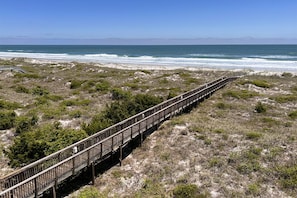 A wooden boardwalk leading to a beach with ocean views. - Oceanfront escape! Spectacular ocean views, 2 pools, tennis & elevator! (Wrightsville Beach)