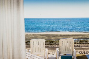 Two white chairs facing a beach with a view of the ocean and a jet ski in the distance. - Casa Olé – Oceanfront, Sleeps 6, Rocky Point (Puerto Peñasco)