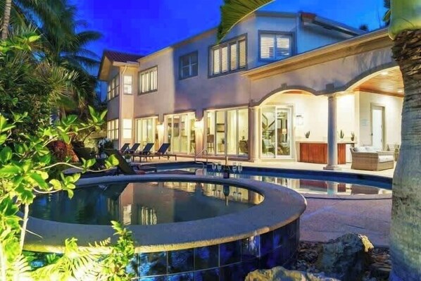 A large house with a swimming pool, a covered patio, and a well-maintained garden. - Delray Beach Intracoastal Elegance Waterfront pool (Delray Beach)