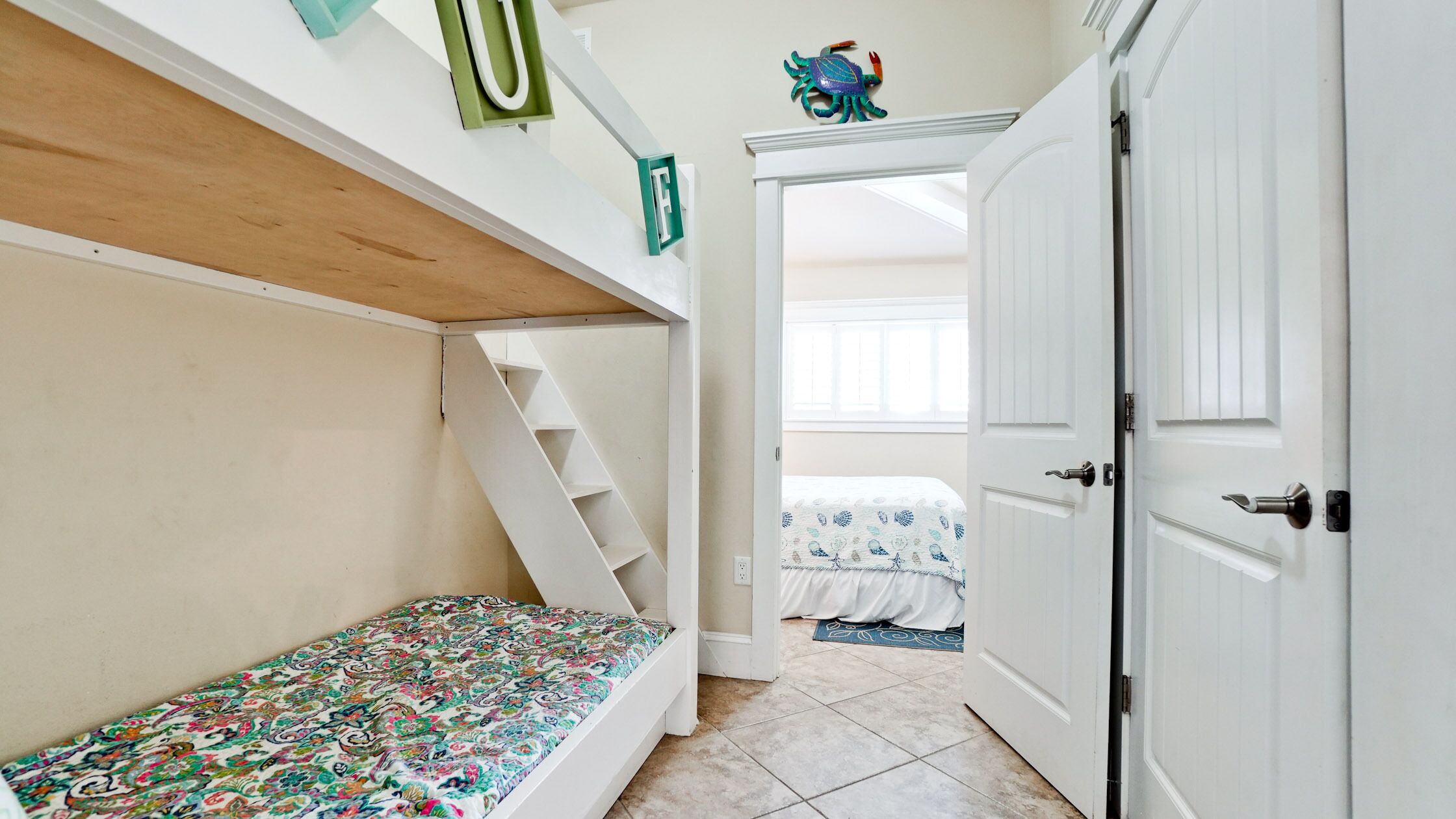 Un dormitorio con una litera, una puerta y una escalera.