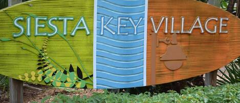 En skylt med texten ”SIESTA KEY VILLAGE” och en bild av en nyckel.