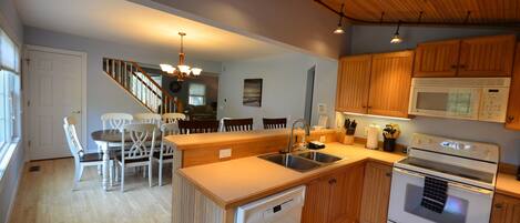 A compact kitchen with wooden cabinets, a built-in dishwasher, a microwave, and a stove.