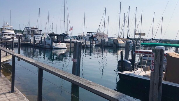 Un port de plaisance où de nombreux bateaux sont amarrés à des quais en bois.