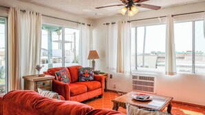 A living room with a red sofa, a wooden coffee table, and a ceiling fan.