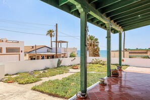 A covered outdoor area with a patio, plants, and a view of the sea. - Las Mareas 21 – Ocean View, Las Conchas (Puerto Peñasco Centro)