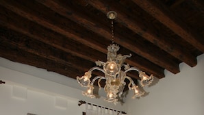 Ein Essbereich mit Holztisch und roten Stühlen, einer weißen Couch und einem Kronleuchter.