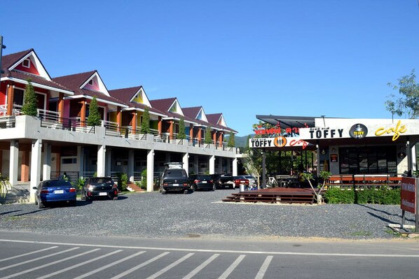 Une rangée de maisons aux couleurs vives, avec une enseigne « Toffy Cafe ».