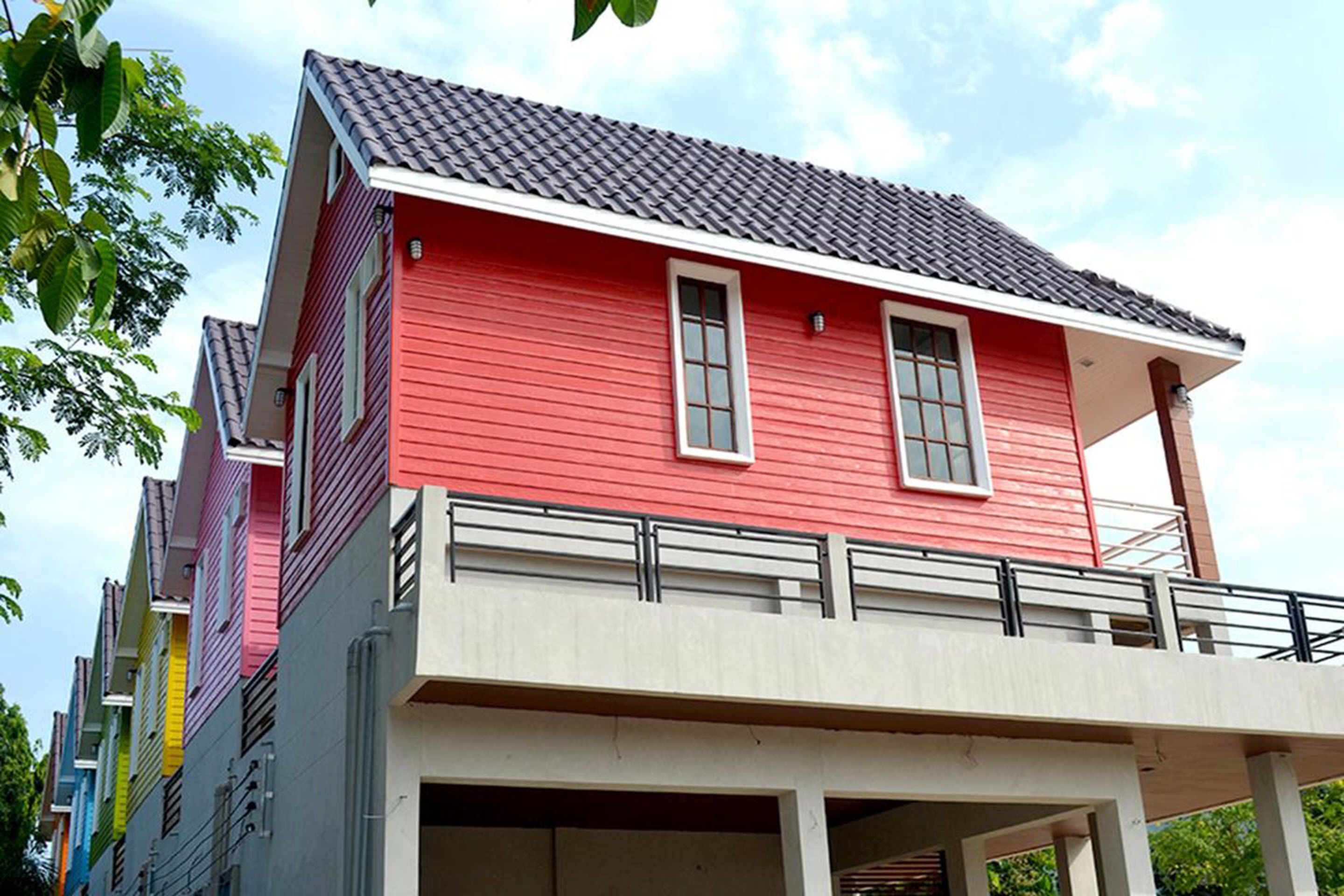 A red building with a balcony and a garage.