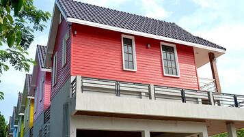Un edificio rojo con balcón y garaje.