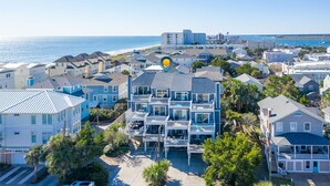 A coastal residential area with multi-story houses, a beach, and a clear view of the ocean. - Relaxing townhouse with beautiful ocean views and just steps to the beach! (Wrightsville Beach)
