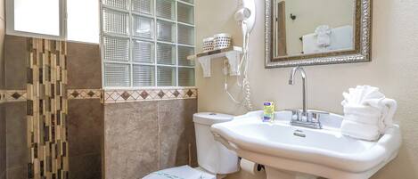A bathroom with a toilet, sink, and window with blinds.
