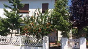 A two-story building with a white facade, brown shutters, and a white lattice fence. - Sunny apartment in a residential area, not far from the historic center (Pisa)