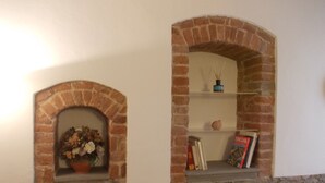 A fireplace with a brick arch and a shelf above it.