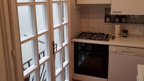 A kitchen with white cabinets, a gas stove, an oven, and a dishwasher.
