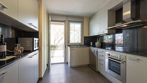 Een moderne keuken met roestvrijstalen apparatuur, een vaatwasser en een ruime oven.